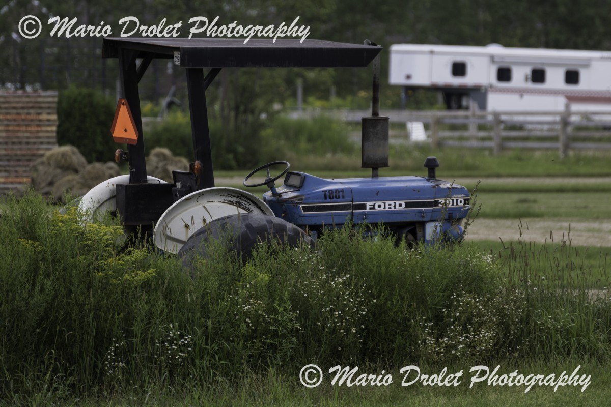 Colour photo of an old tractor abandoned in a field
