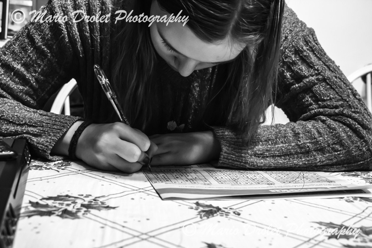 Black and White photo of someone doing sudoku puzzles