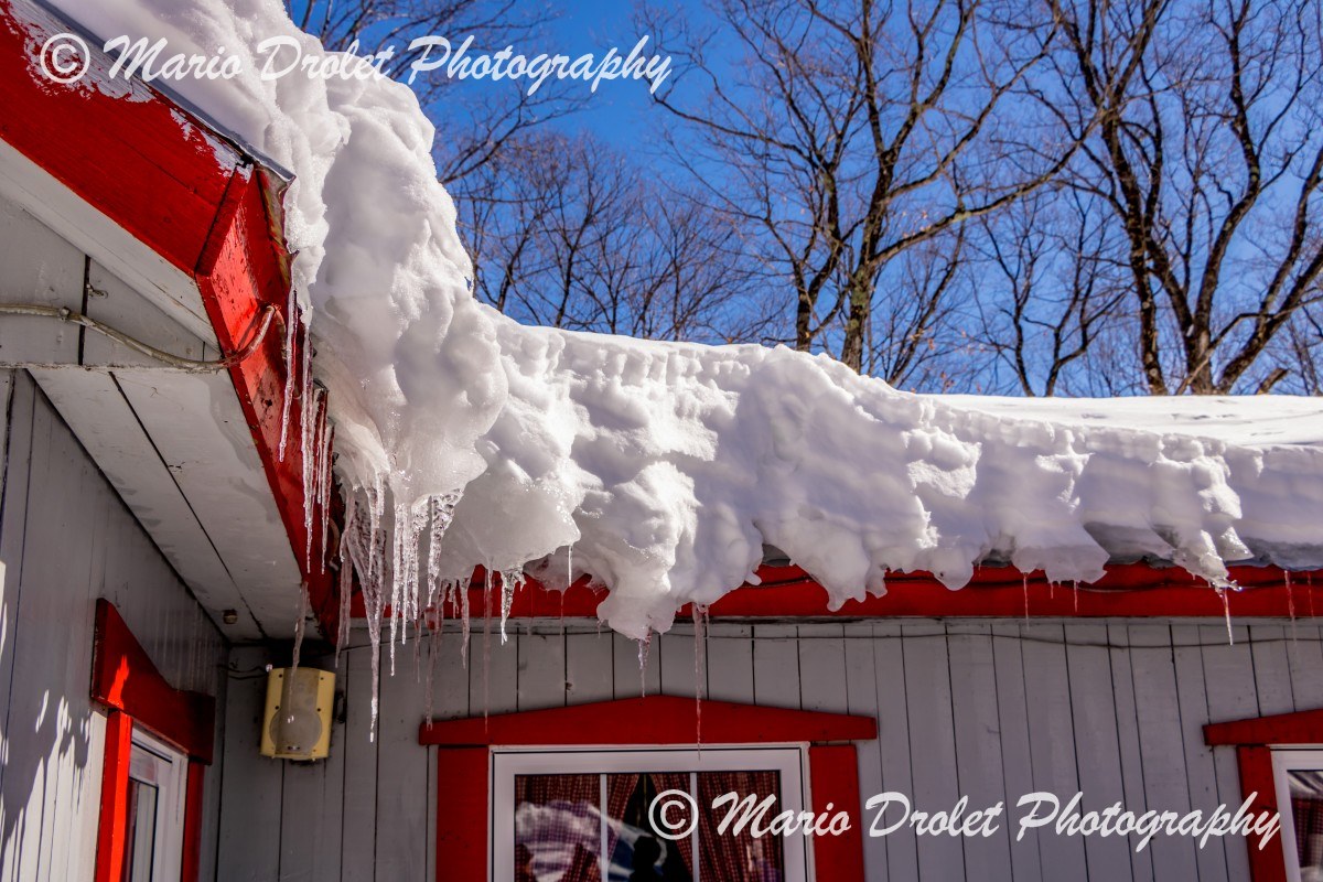 Snow and icicles on a building roof in the spring