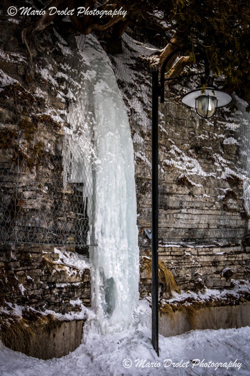 Frozen waterfall over a brick wall