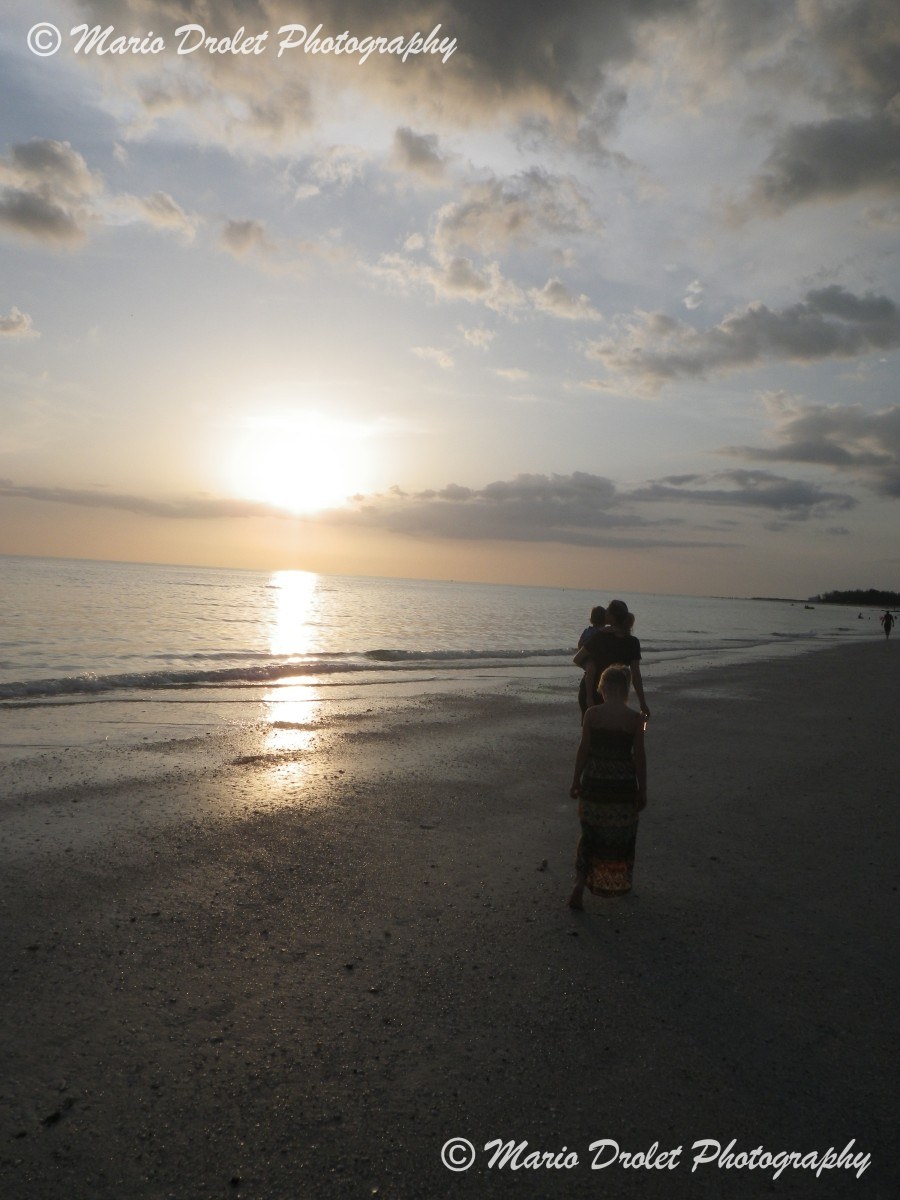 Family walking on the beach at sunset